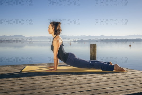 An image of a pretty woman doing yoga at the lake