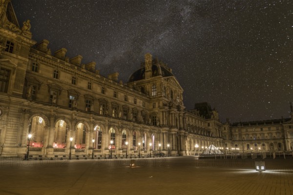 Scenic starry night sky above the Parisian Louvre Palace, France, Europe