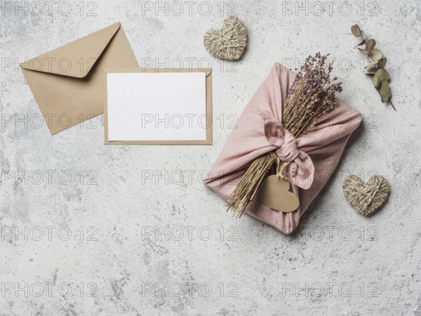 Zero waste Valentine's Day concept and mock up. Eco-friendly gift cloth wrapping in Furoshiki style, craft paper envelope, empty gift or greetings card, copy space