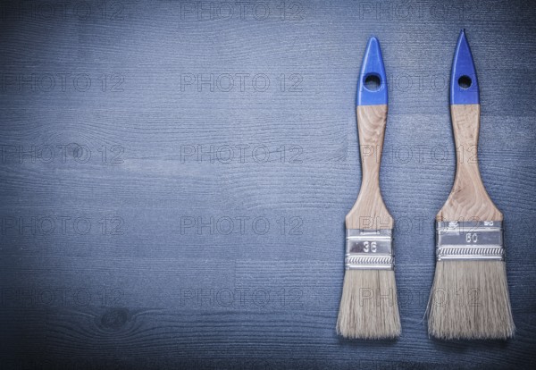 Paint brushes on wooden board construction concept