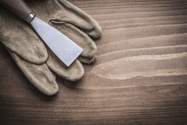 Paint scraper on protective glove