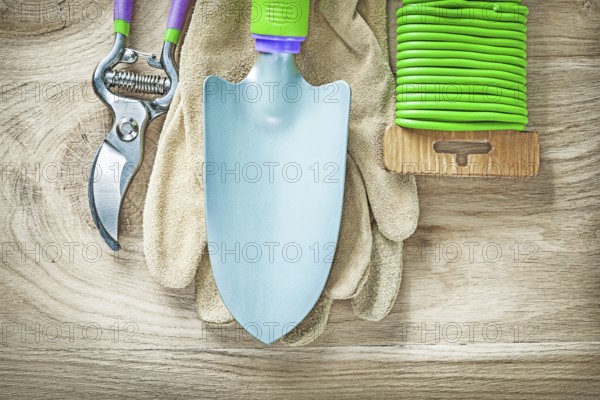 Working gloves secateurs hand spade garden soft tie on wooden board gardening concept