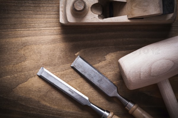 Wooden mallet shaving plane firmer chisels on wood board construction concept