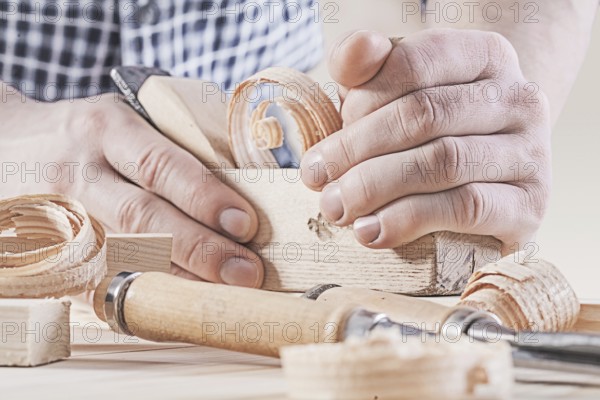 Woodworkers plane in hands of carpenter very close up