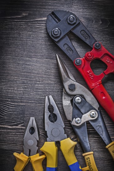 Metal wire steel cutter pliers on wood board construction concept