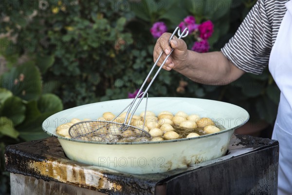 Woman cooking traditional delicious greek loukoumades honey pastry