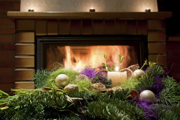 Christmas floral table decoration in front of the fireplace with candles
