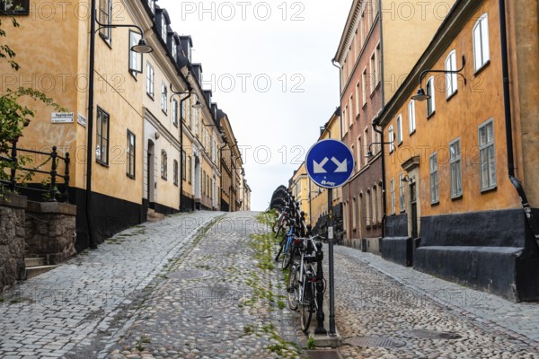 Stockholm, Sweden, August 8, 2019: Bicycles parked in picturesque cobblestoned street in Ugglan quarter in Sodermalm, Europe
