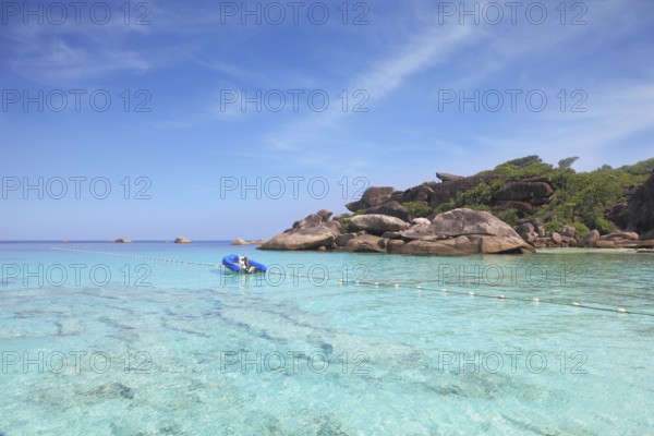 Exotic tropical Similan Islands. Clear azure ocean water. Moored in the bay inflatable boat