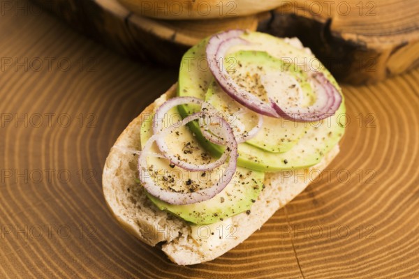 Sandwich with avocado, red onion, salt and herbs