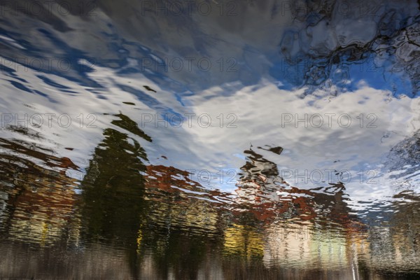 Buildings reflected in the river Mur, Leoben, Styria, Austria, Europe