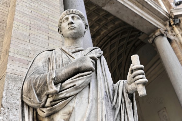 Historical marble statue of a person holding a scroll in front of a classical column structure, Rome, Lazio, Italy, Europe