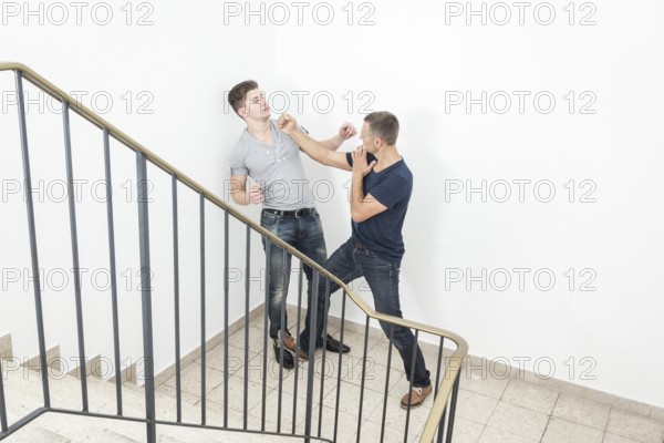An image of a two men fight at the staircase