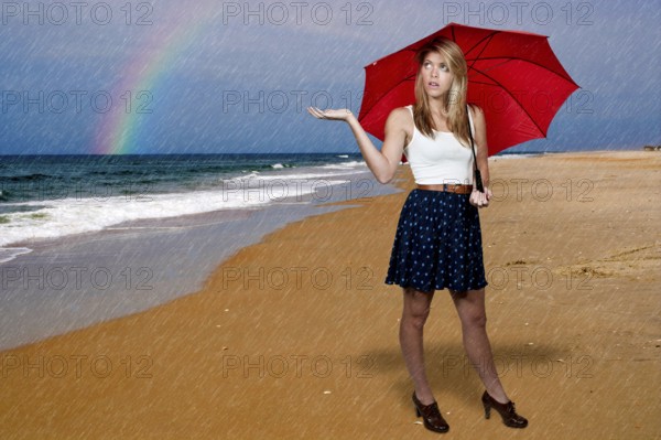 A beautiful young woman holding an umbrella in the rain