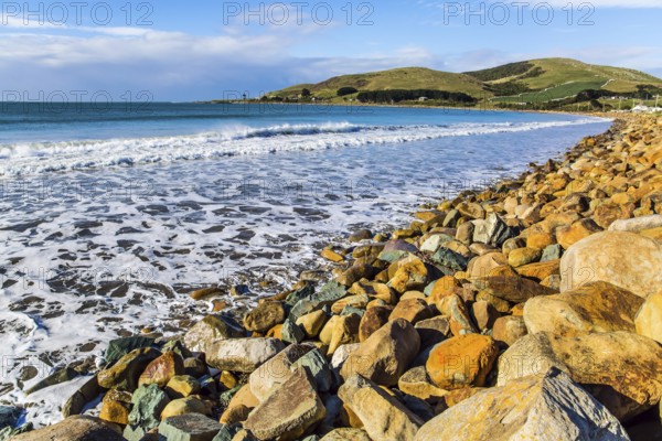 Sunset. Rocky and stone shores of the ocean. The southernmost point of New Zealand. The concept of ecological and photo tourism