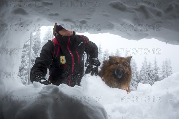 Sofia, Bulgaria - January 18, 2017: Rescuer from Mountain rescue service at Red Cross organization participates in a training with his dog. Both men and animals are trained before going on duty