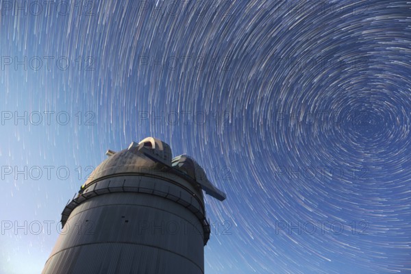 Astronomical observatory under the night sky stars. Blue sky with hundreds of stars of the Milky way. Timelapse in comet mode