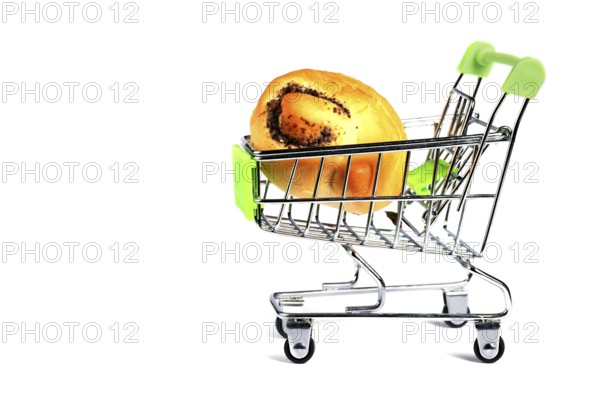 Miniature supermarket trolley with a bread roll on a white background