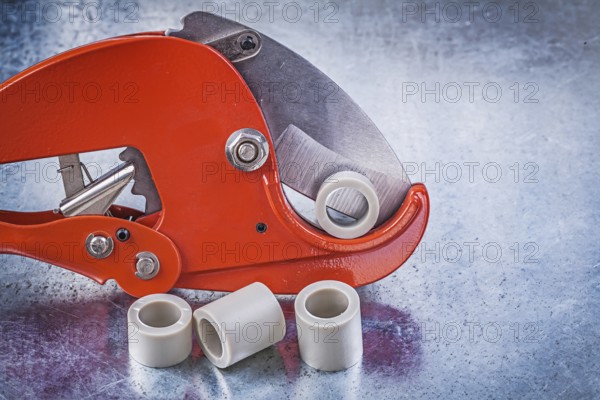 Pipe cutter water tube on metallic background construction concept