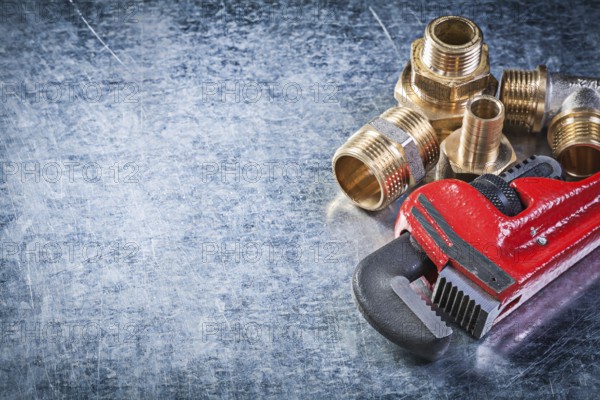 Monkey wrench brass nipple hose connectors on metallic background plumbing concept