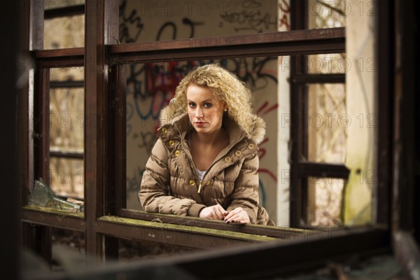 Young blonde woman with long curly hair in outdoor autumn environment