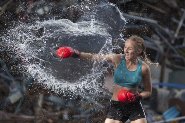 Boxer hits water balloon powerfully, proof of strength and determination, staged photo shoot, Mindelheim, Bavaria, Germany, Europe