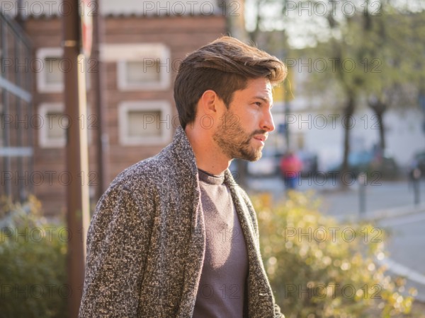 One handsome young man in urban setting in European city, standing