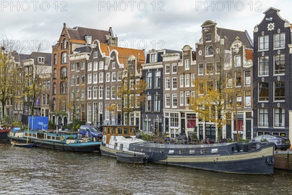 Row of stately buildings along the canal as autumn colours the trees, Amsterdam, Netherlands