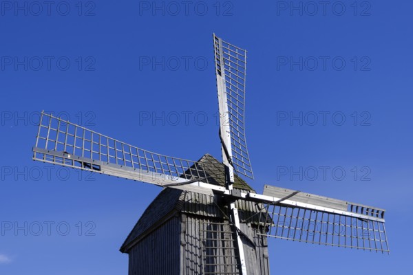 Windmill with wooden sails under a clear blue sky, traditional rural structure, borken, münsterland, germany