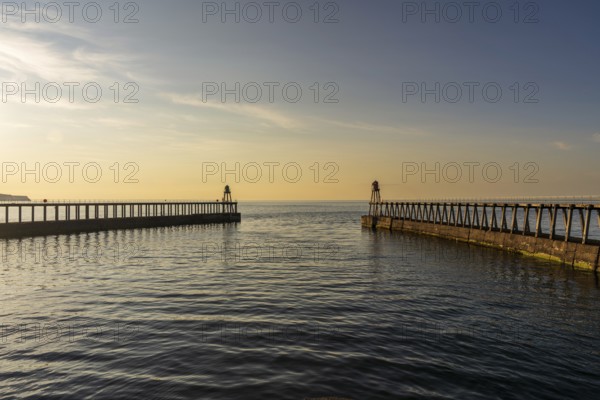 Golden Hour at the West and East Pier in Whitby, North Yorkshire, England, UK