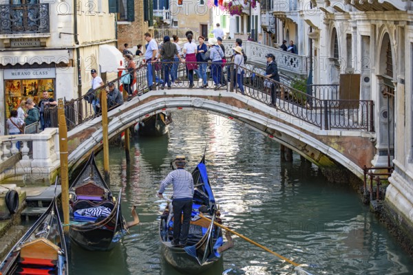 Tourists taking gondola, the traditional Venetian boat, on canal in Venice, Italy, Europe