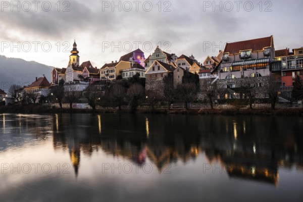 Christmas illuminated house facade of Frohnleiten reflected in the river Mur, Frohnleiten, Styria, Austria, Europe