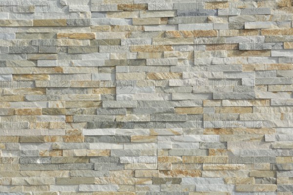 Thin natural stones form a pattern in a stone wall