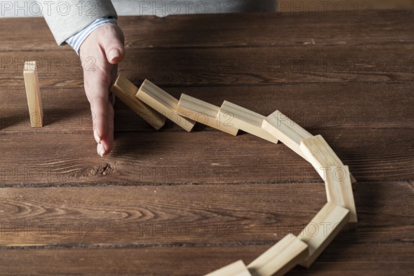 Business woman block domino effect. Business assistance, risk management and stabilisation situation. Intervention in process concept with wooden blocks on table. Protection from economic collapse