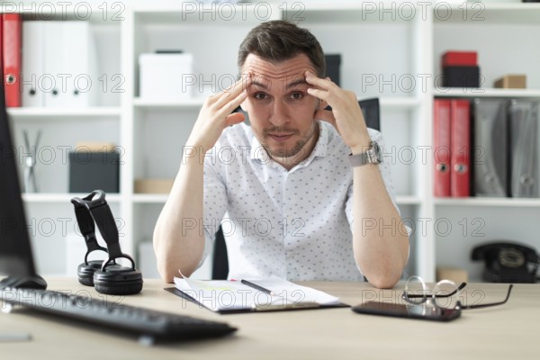 A young man in blue trousers and a light shirt. A handsome young man with a stubble on his face. photo with depth of field