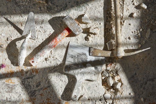 Mason tools on debris background in house improvement construction