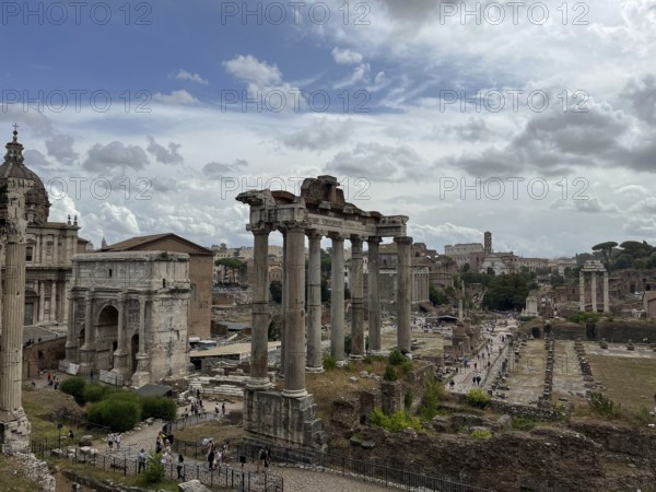 Wide view of ancient ruins with columns under a cloudy sky, Rome, Italy, Europe