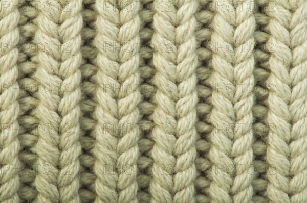 Old knit sweater background. Beige color. Studio shot