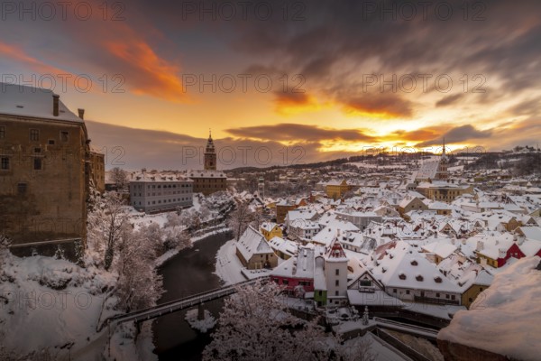 Winter view of Cesky Krumlov, picturesque houses under the castle with snow-covered roofs. Narrow streets and the Vltava river. Travel and Holiday in Europe. Christmas time. UNESCO World Heritage. Czech Republic