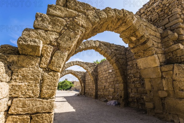 Picturesque ruins of the ancient city of Caesarea. Israel. Sunny spring day. Arched passage - covered street of Port of Caesarea. Concept of ecological and historical tourism
