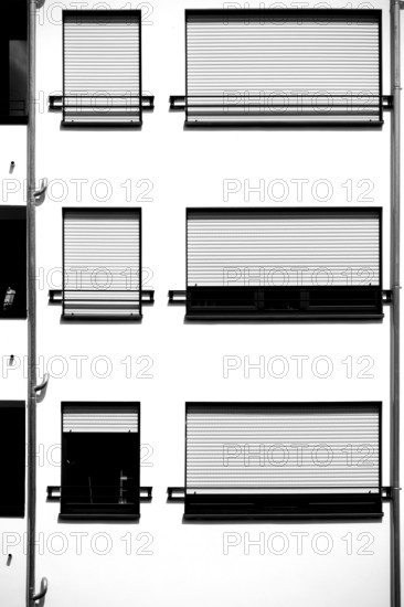 The modern façade of a modern residential building with a metal window with metal blinds
