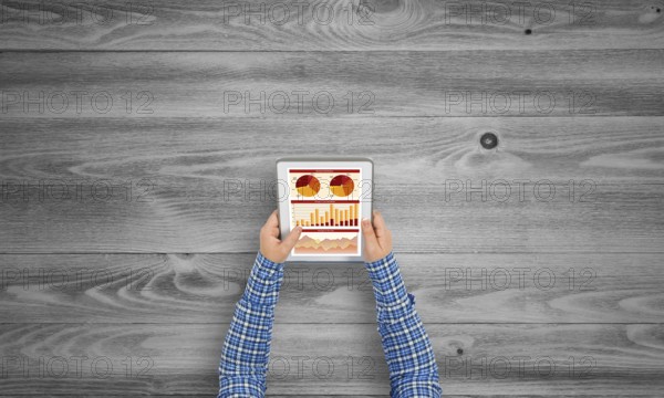 Top view of girl hands using tablet pc with diagrams and graphs on screen