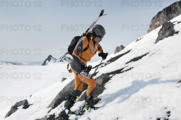 AVACHA VOLCANO, KAMCHATKA PENINSULA, RUSSIA, APR 22, 2012: Open Cup of Russia on ski-mountaineering on Kamchatka. Ski mountaineer climbing on the rock with skis strapped to a backpack