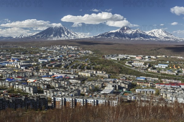 Panoramic view of the city Petropavlovsk-Kamchatsky and volcanoes: Koryaksky Volcano, Avacha Volcano, Kozelsky Volcano. Russian Far East, Kamchatka Peninsula