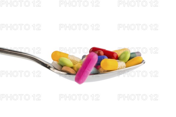 Many colourful tablets on a spoon. Symbolic photo for tablet addiction and misuse of medication. Austria