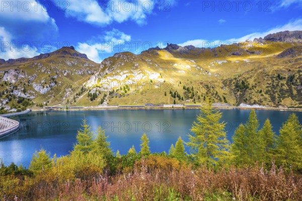 Glacial lake with clear cold water. The concept of ecological tourism. The harmony of the Dolomites. Mountain Lake Lago di Fedaia