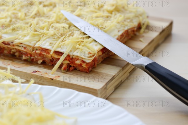 Salt cake with cheese and red paprika on wooden table with knife