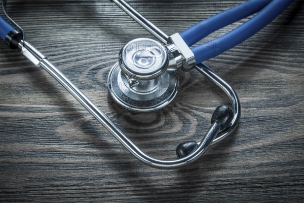 Medical stethoscope on wooden board top view