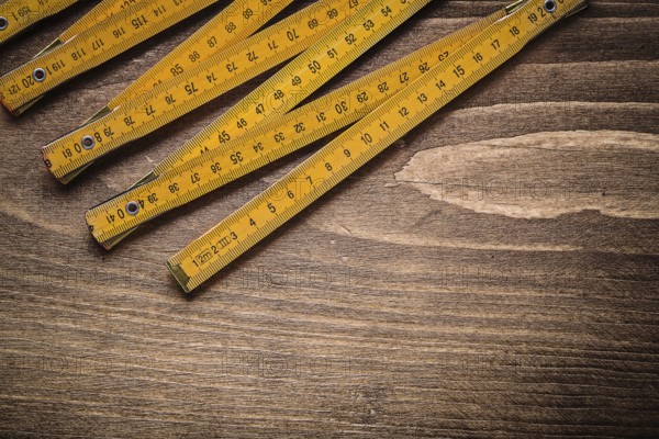 Yellow wooden meter on wood board top view construction concept