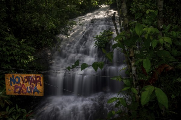 Colombia in December 2015: A Spanish sign reading No Votar Basura urges the visitor of a beautiful waterfall not to pollute the environment. Tourists should always take their rubbish